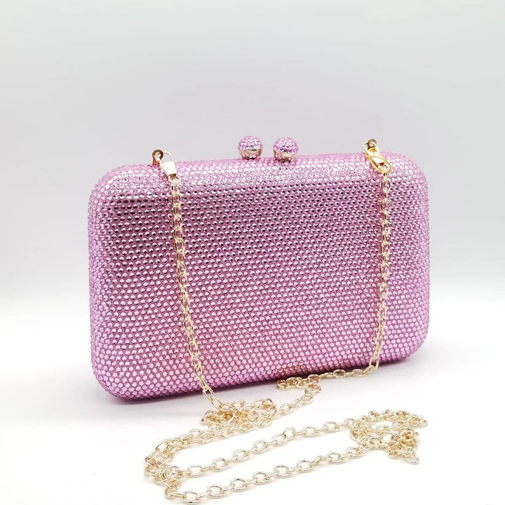Borsetta da cerimonia rigida con strass color rosa e tracolla interna removibile.